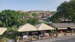 a group of umbrellas with tables and chairs at Petalidi Square in Petalidi