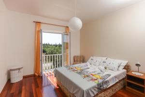 Un dormitorio con una cama y una ventana grande. en Apartments Vila Harmonia, en Čilipi 26 fotos más