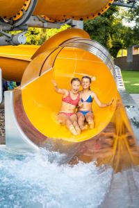 two girls riding a roller coaster on a water slide at Appartement Bettina in Schoppernau