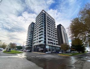 a tall building on a street with cars parked in front at Pionero in Neuquén