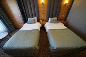two beds sitting in a small room with at Green Prusa Hotel in Bursa