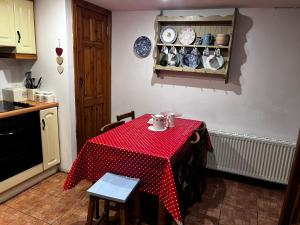 une cuisine avec une table et un chiffon rouge et blanc dans l'établissement No 30 Cottage , Moville, à Moville