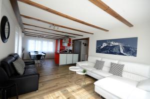ein Wohnzimmer mit weißen Möbeln und eine Küche in der Unterkunft Lake House in Bönigen