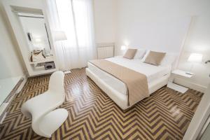 una camera con un letto e una sedia di Home Boutique Luxury & Design a Reggio di Calabria