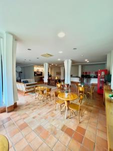 a room with tables and chairs and a kitchen at Violeta Meaípe Hotel in Guarapari +12 photos