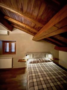 Schlafzimmer mit einem Bett und Holzbalkendecken mit Balken in der Unterkunft Il Viaggiatore Appartamento in Anagni