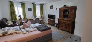 a living room with a bed and a tv at Ferienwohnungen Heinrichsberger in Bad Aibling