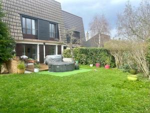 a backyard of a house with a large lawn at Nice new apartment with direct access a big garden in Saint-Germain-en-Laye