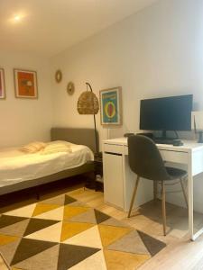 a bedroom with a desk with a computer and a bed at Nice new apartment with direct access a big garden in Saint-Germain-en-Laye