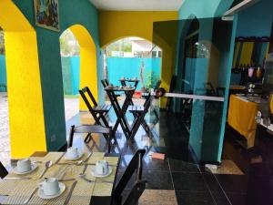 Pousada Sereia Tropical في غوارويا: غرفة طعام فيها طاولة وكراسي