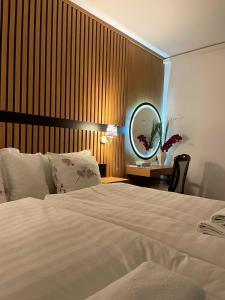 a bedroom with a bed with a mirror and a table at Swiss Plus Hotel in Bihać