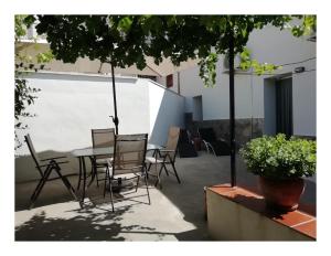 a patio with a table and chairs and a plant at Casa Rural El Abejorro in Alcalá del Júcar