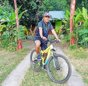 un hombre montando una bicicleta por un camino en Lendang Eco Lodge en Senggigi 