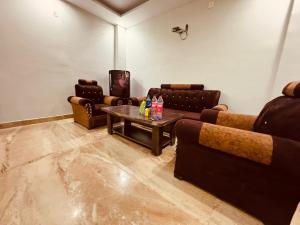 a living room with couches and a coffee table at Aston Hills Rooms & Cottages Tapovan in Rishīkesh