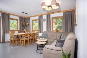 ein Wohnzimmer mit einem Sofa und einem Esszimmer in der Unterkunft Ibex Apart in Aschau