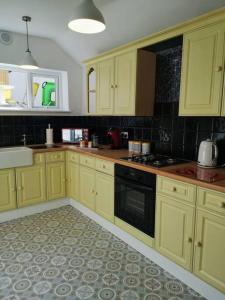 uma cozinha com armários amarelos e um forno com placa de fogão em HARBOUR VIBES em Weymouth
