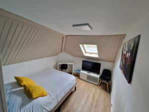 een slaapkamer met een bed en een flatscreen-tv bij Castle room in Pierrefonds