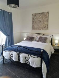 um quarto com uma cama com um cobertor azul e branco em HARBOUR VIBES em Weymouth