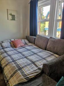 um sofá com um cobertor na sala de estar em HARBOUR VIBES em Weymouth