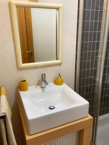 bagno con lavandino bianco e specchio di Maura's Holiday House a Silveira