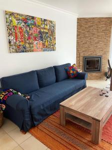 a living room with a blue couch and a coffee table at Maura's Holiday House in Silveira