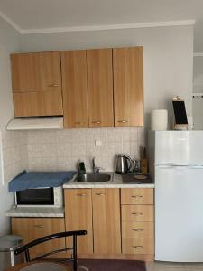 Una cocina con gabinetes de madera, un fregadero y un refrigerador. en Kate's Studio with view and free parking, en Serres 4 fotos más