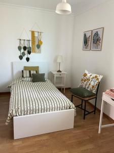 a bedroom with a bed and a chair and a desk at Maura's Holiday House in Silveira