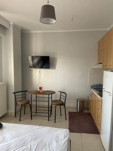 cocina con mesa y sillas y cocina con nevera en Kate's Studio with view and free parking, en Serres
