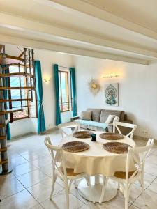 a living room with a table and chairs at Le St Julien Terrasse vue mer exceptionnelle in Menton