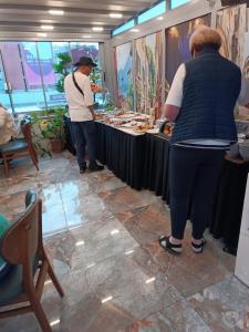 two people standing at a buffet in a restaurant at Grand Bona Sera Hotel in Istanbul