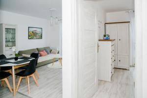 a white living room with a table and a couch at Apartament Reda in Reda