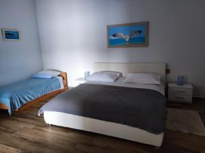 Apartment Mareta in Viganj في فيغاني: غرفة نوم بسريرين وصورة طيور على الحائط