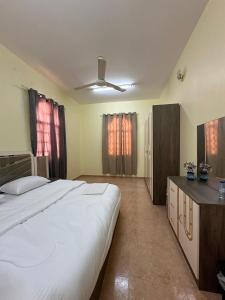 a bedroom with a large bed and a ceiling fan at Blossoms hills apartment in Samhān