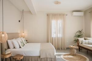 a white bedroom with a bed and a couch at Marissa's Elegant retreats in Argostoli