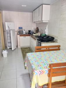 una pequeña cocina con mesa y nevera en Morada do Neu Ingleses, en Florianópolis