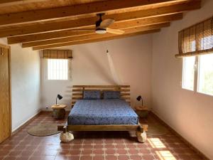 - une chambre avec un lit dans une pièce dotée de plafonds en bois dans l'établissement Casita Abanilla, à Murcie