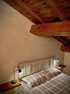 Schlafzimmer mit einem Bett mit zwei Lampen und Holzdecken in der Unterkunft Il Viaggiatore Appartamento in Anagni