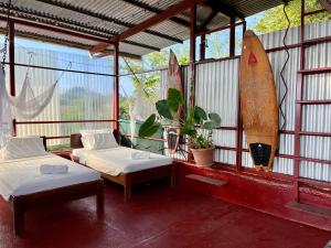 pokój z 2 łóżkami i deską surfingową w obiekcie Villas Jacquelina w mieście Quepos