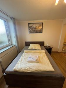um quarto com uma cama com uma toalha em SkyPension em Schönefeld