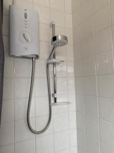 een douche met een douchekop in de badkamer bij swane house in Brislington