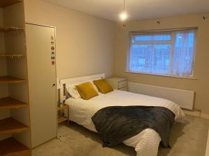 Un dormitorio con una cama con almohadas amarillas y una ventana en swane house en Brislington