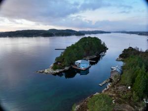 an island in the water with a house on it at Floating House Bergen in Bergen