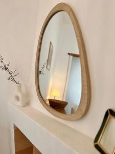 a mirror sitting on a shelf in a bathroom at Casetta Bianca con Giardino in Posada