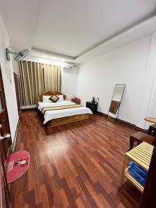 1 dormitorio con 1 cama y suelo de madera en KHÁCH SẠN PHƯƠNG DUNG, en Dak Rơleang