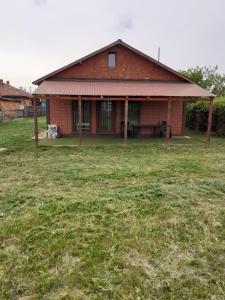 ein Haus mit einem Grasfeld davor in der Unterkunft Cabana OTE Soft in Snagov
