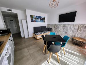 a kitchen and a living room with a table and chairs at Apartamentos Playa De Covachos in Soto de la Marina