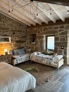 a bedroom with two beds and a stone wall at ATURUXO 