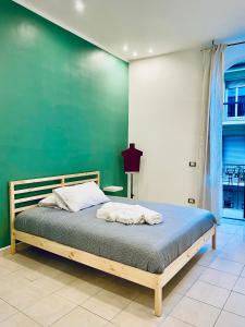 Cama en habitación con pared verde en Cinque Terre Casa Gina La Spezia, en La Spezia