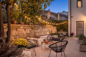 a patio with a table and chairs and lights at Marissa's Elegant retreats in Argostoli