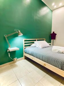 1 dormitorio con una pared verde, 1 cama y 1 lámpara en Cinque Terre Casa Gina La Spezia, en La Spezia